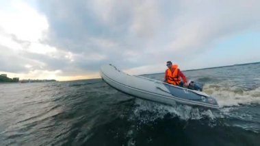 Can yeleği giyen kişi nehirde motorlu tekneye biniyor..