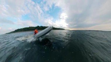 Dalgalar üzerinde bir tekne yelken Adam.