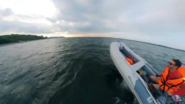 Un hombre conduce en barco inflable en olas . — Vídeos de Stock