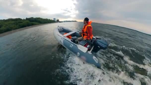 Pessoa que navega um barco inflável perto da costa . — Vídeo de Stock