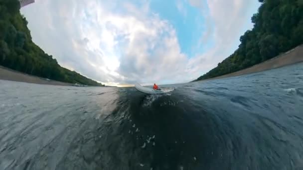 Egy személy, aki egy fehér csónakot lovaglás a partközeli folyón. — Stock videók