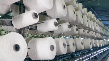 Tekstil bitki makinesi bir raf üzerinde elyaf ile clews makaralar. Tekstil fabrikası ekipmanları iş yerinde.