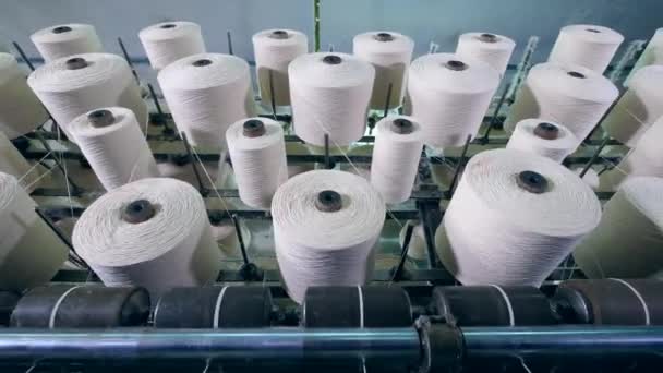 De nombreuses bobines avec filage de fibres sur une machine d'usine dans une installation. Équipement d'usine textile dans le travail . — Video