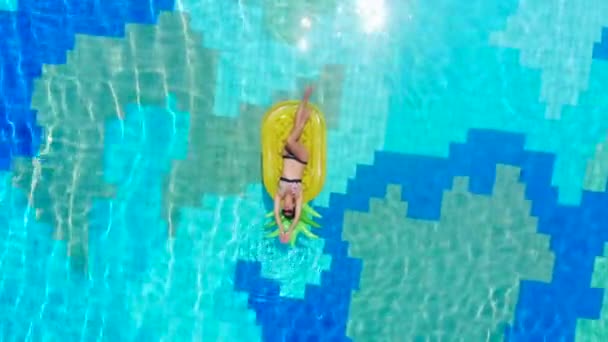 Een dame op de luchtmatras in het zwembad in een top uitzicht — Stockvideo