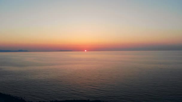 The sun is setting into the calm ocean — Αρχείο Βίντεο