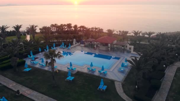 Курорт з басейном і долонями на заході сонця — стокове відео