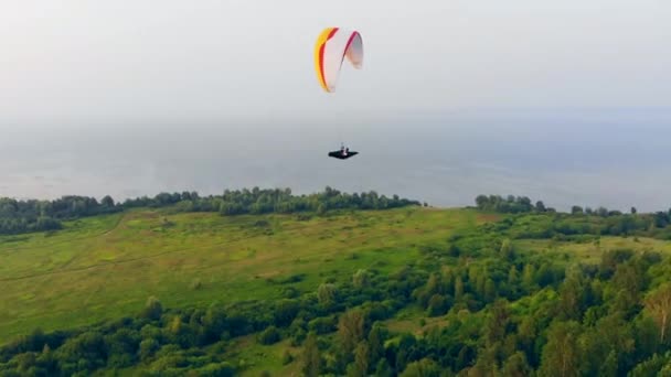 Um desportista a voar no céu com um parapente. Parapente no céu . — Vídeo de Stock