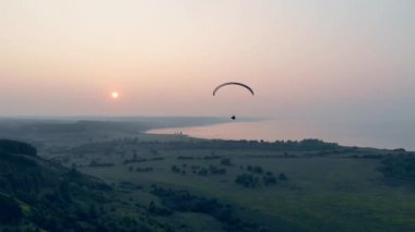 Gökyüzünde yamaç paraşütüyle eğitim alan bir adam. Gökyüzünde yamaç paraşütü.