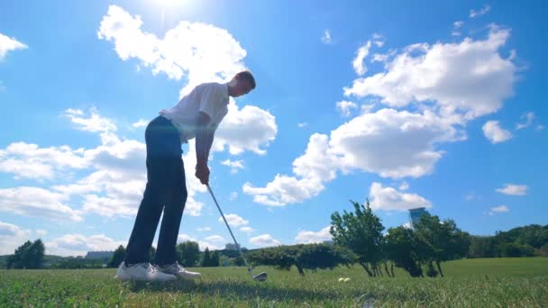 Golfista masculino patea una pelota mientras juega en un campo de golf . — Vídeo de stock
