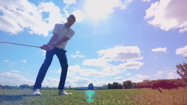 Golfista masculino bate uma bola em um campo enquanto treina . — Vídeo de Stock