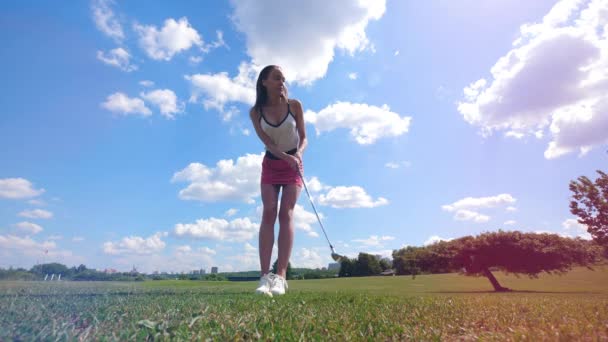 女性ゴルファーは、フィールドで遊んでいる間にボールを打ちます. — ストック動画