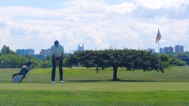 Игрок в гольф бьет клюшкой по мячу для гольфа . — стоковое видео