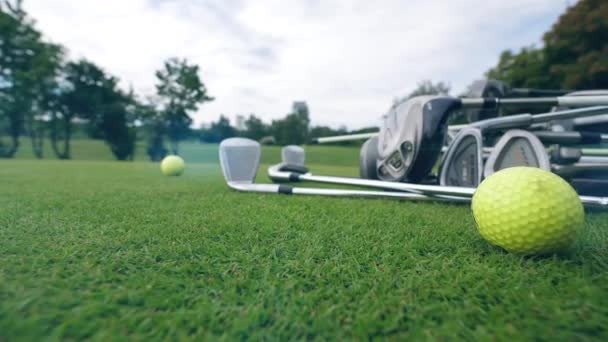 Clubes de golf y pelota tumbados en un campo de golf . — Vídeos de Stock