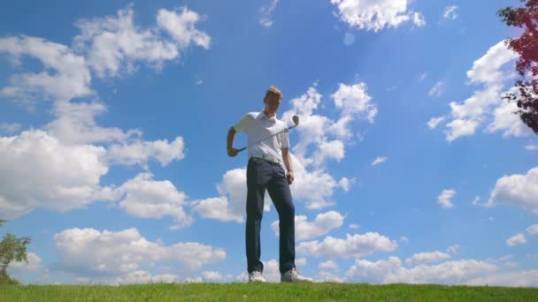 En man jonglerar golfboll med en golfklubba. — Stockvideo
