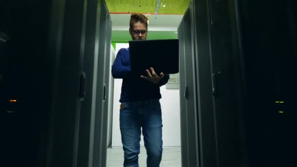 Engenheiro de informática está caminhando ao longo do datacenter — Vídeo de Stock