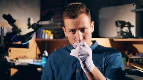 Male jeweller measures a ring with a gemstone. — Stock Video