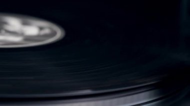 Adam bir vinil disk üzerine bir müzik çalar iğne koyar.