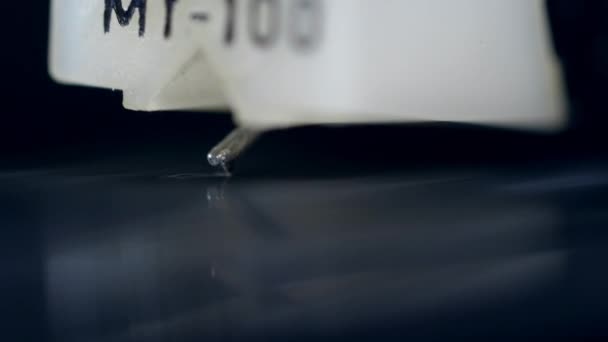 En vinylskiva repad med en nål för att spela musik på en enhet. — Stockvideo