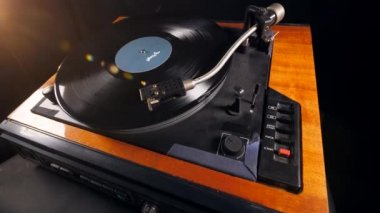 Bir adam bir iğneyi vinil diskten uzaklaşır ve alır..