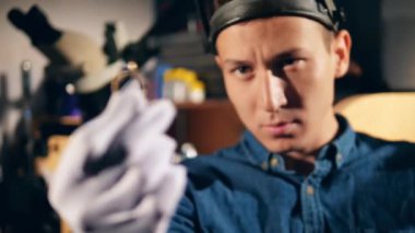 Profesyonel kuyumcu bir değerli taş ile bir yüzük, gözlük takan.