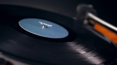 Bir kişi bir plak üzerine bir vinil çalar metal iğne koyar.