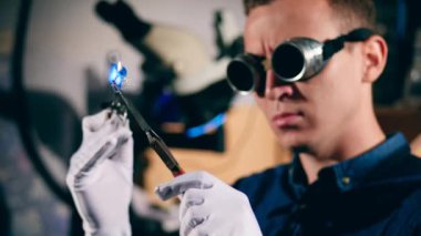 Profesyonel kuyumcu bir mücevher atölyesinde gümüş bir yüzük kaynak.