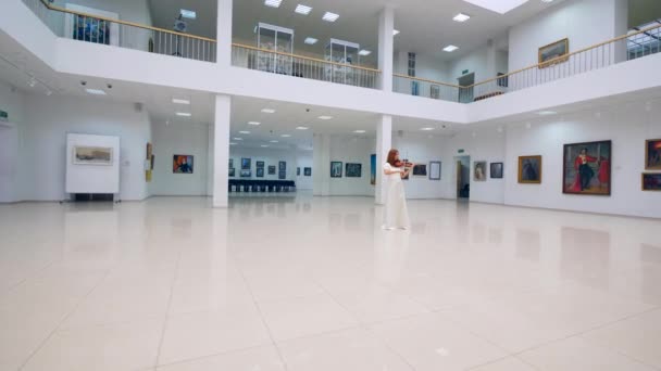 Salle de la galerie avec une femme en robe jouant du violon — Video