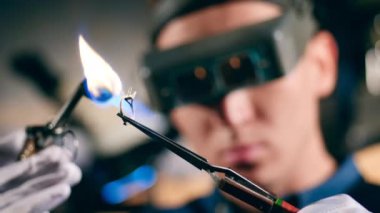 Bir kuyumcu bir yüzük ile çalışırken kaynak makinesi kullanır.