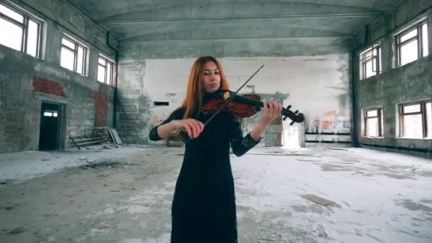 Construção encalhada com uma senhora tocando violino — Vídeo de Stock