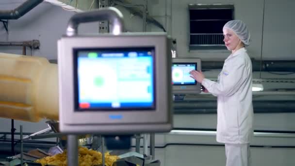 Arbeiter einer Lebensmittelfabrik steuert ein Förderband voller Kartoffelchips. — Stockvideo