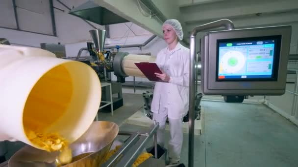 One woman checks work of automated conveyor, moving chips into a container. — Αρχείο Βίντεο