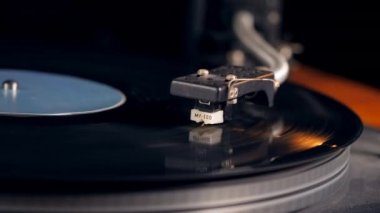 Bir vintage gramofon çalışır, dönen siyah vinil disk.