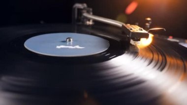 Adam çalışan bir vinil çalar kapatır, bir iğne alarak uzağa.