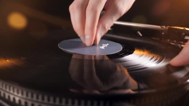 En person placerar en svart skiva på en vinylspelare och trycker på en knapp. — Stockvideo