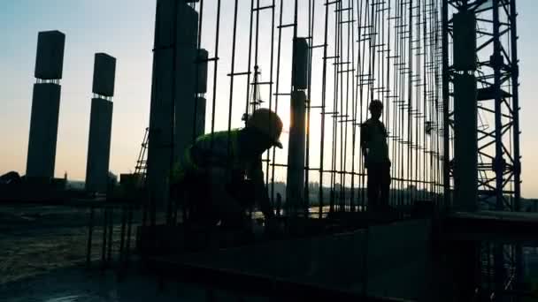 Arbeiter bauen Metallkarkasse auf dem Baugrundstück