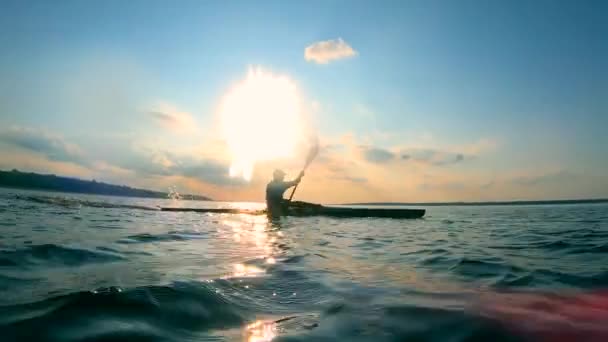 Человек плывет на каяке по воде — стоковое видео
