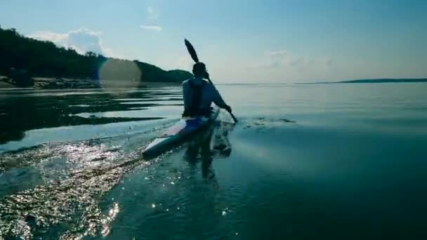Pomalý pohyb muže veslovat přes jezero — Stock video