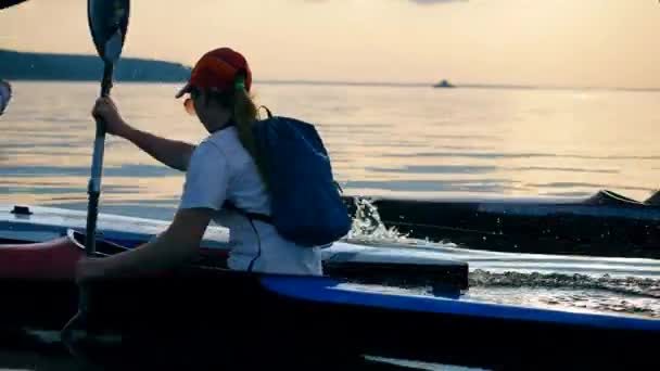 Вид сзади на женщину, плывущую на каноэ — стоковое видео