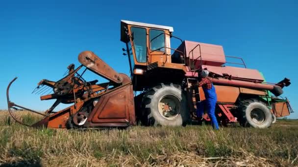 Агроном садится в трактор на поле . — стоковое видео