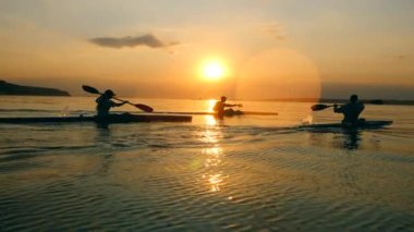 İnsanlar kürek ile Sunset waterscape