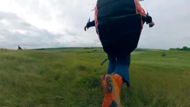 Uma pessoa salta para voar um parapente . — Vídeo de Stock