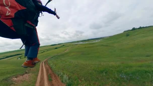 Eine Person landet nach einem Flug mit einem Segelflugzeug auf einem Feld. — Stockvideo