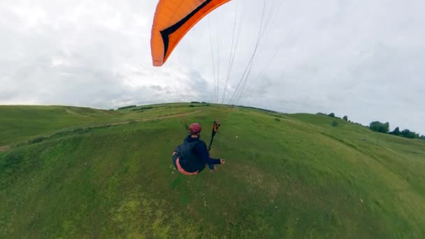 Person flyger en paraglider och landar på marken. — Stockvideo