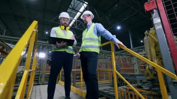 Dos inspectores están hablando en la planta, fábrica moderna — Vídeos de Stock