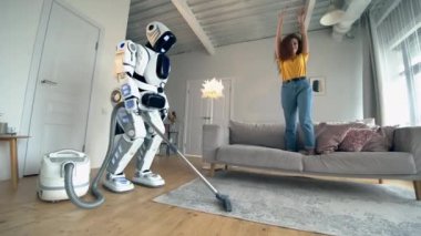Cyborg, bayan kanepede dururken hoovering. Akıllı ev konsepti.