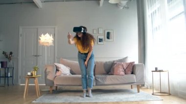 Vr-gözlükhareket eden genç bir kadın ile oturma odası. Akıllı ev konsepti.