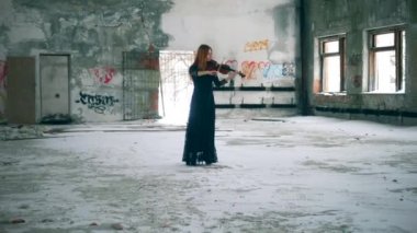 Kişi duvarlarda grafiti ile bir odada keman çalar.
