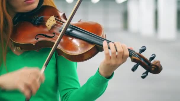 Una mujer sostiene violín de madera mientras actúa sola . — Vídeo de stock