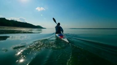 Nehir bir erkek kürekçi tarafından geçleniyor.