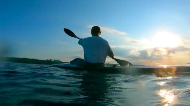 Sunset river y un hombre remando a través de ella — Vídeos de Stock